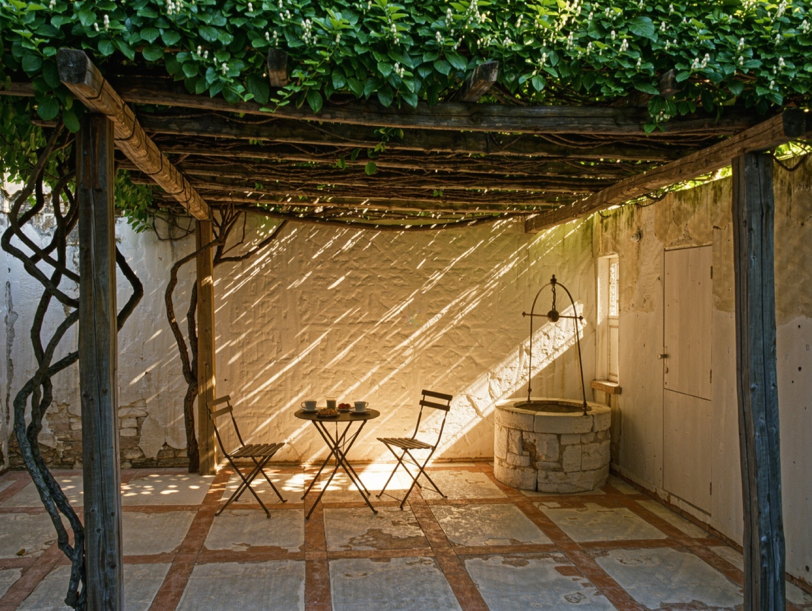Il cortile interno del B&B con pergolato e tavoli per la colazione